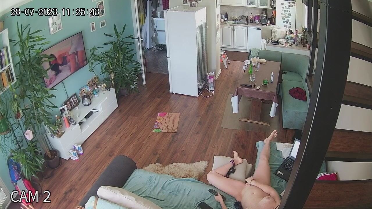 British woman watches TV while fingering her pussy