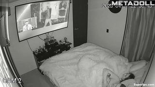 Couple enjoys cozy sex under a blanket in the background of a movie on tv