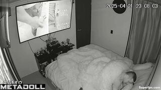 Couple enjoys cozy sex under a blanket in the background of a movie on tv