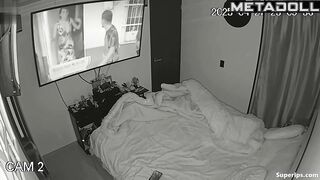 Couple enjoys cozy sex under a blanket in the background of a movie on tv