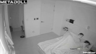 Asian couple making awkward movements in bed, look