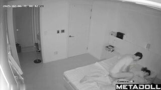 Asian couple making awkward movements in bed, look