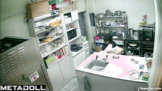 Asian kitchen workers fooling around in a restaurant kitchen