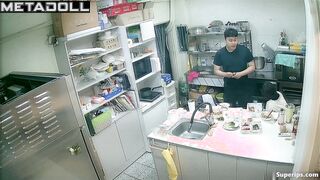 Asian kitchen workers fooling around in a restaurant kitchen