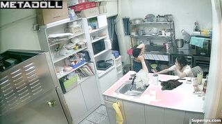 Asian kitchen workers fooling around in a restaurant kitchen