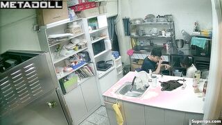 Asian kitchen workers fooling around in a restaurant kitchen