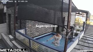 Asian couple enjoying swimming together (inflatable pool in the yard)