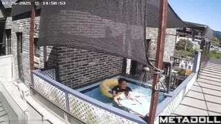 Asian couple enjoying swimming together (inflatable pool in the yard)