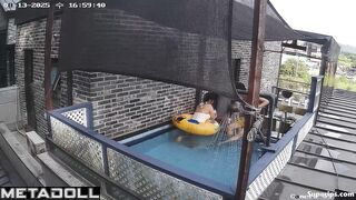 Asian couple enjoying swimming together (inflatable pool in the yard)