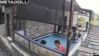 Asian couple enjoying swimming together (inflatable pool in the yard)
