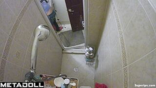A slender blonde gently caresses her body while taking a shower