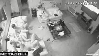 Two naked couples have intercourse in the living room while watching TV