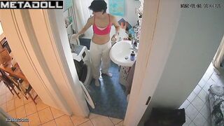 She changes clothes while looking at herself in the mirror