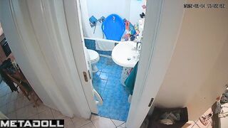 Slim brunette stood on the toilet to clean the ceiling
