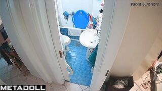Slim brunette stood on the toilet to clean the ceiling