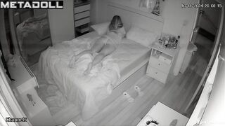 A cute, beautiful girl is lying in bed with her legs spread seductively