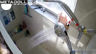 A naked girl is relaxing under the shower in the bathroom